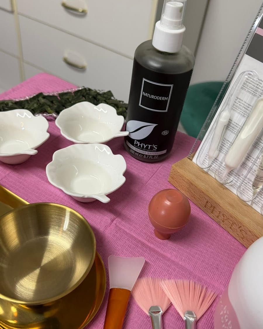 Produits et outils de soin du visage : spray Naturoderm, bols en porcelaine et rouleau de jade
